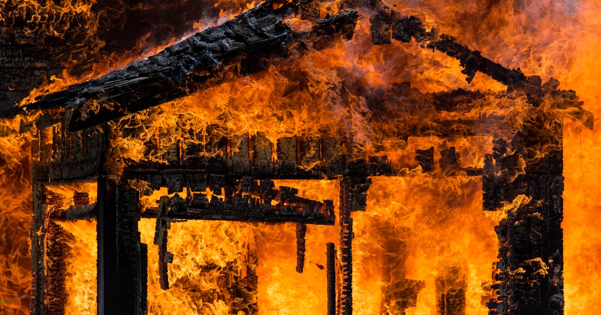 Burning structure with flames consuming wood framing